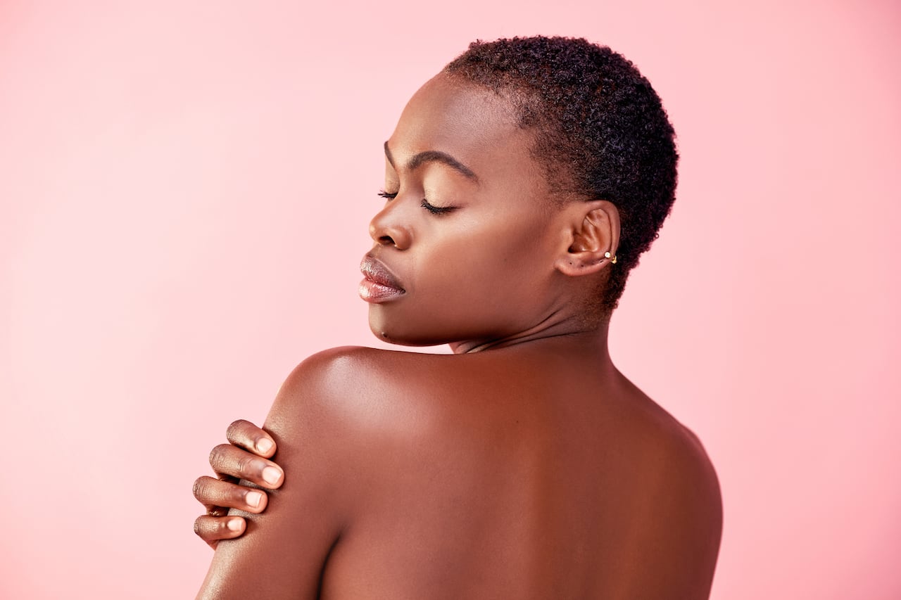 Studio shot of a beautiful young woman posing against a pink background