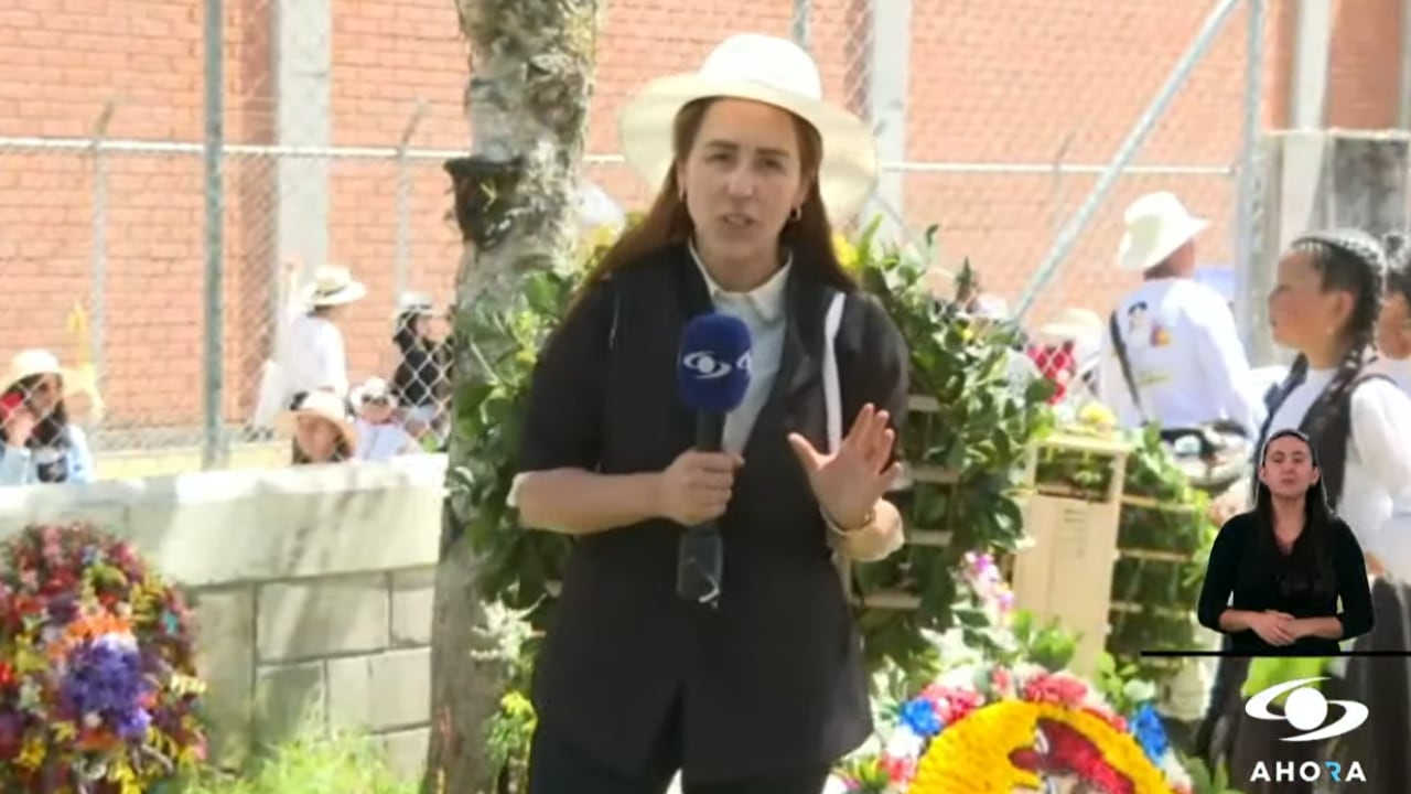Érika Zapata con una silleta de flores en su espalda.