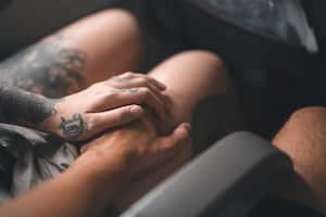 A woman and a man are holding hands on an airplane in flight.
