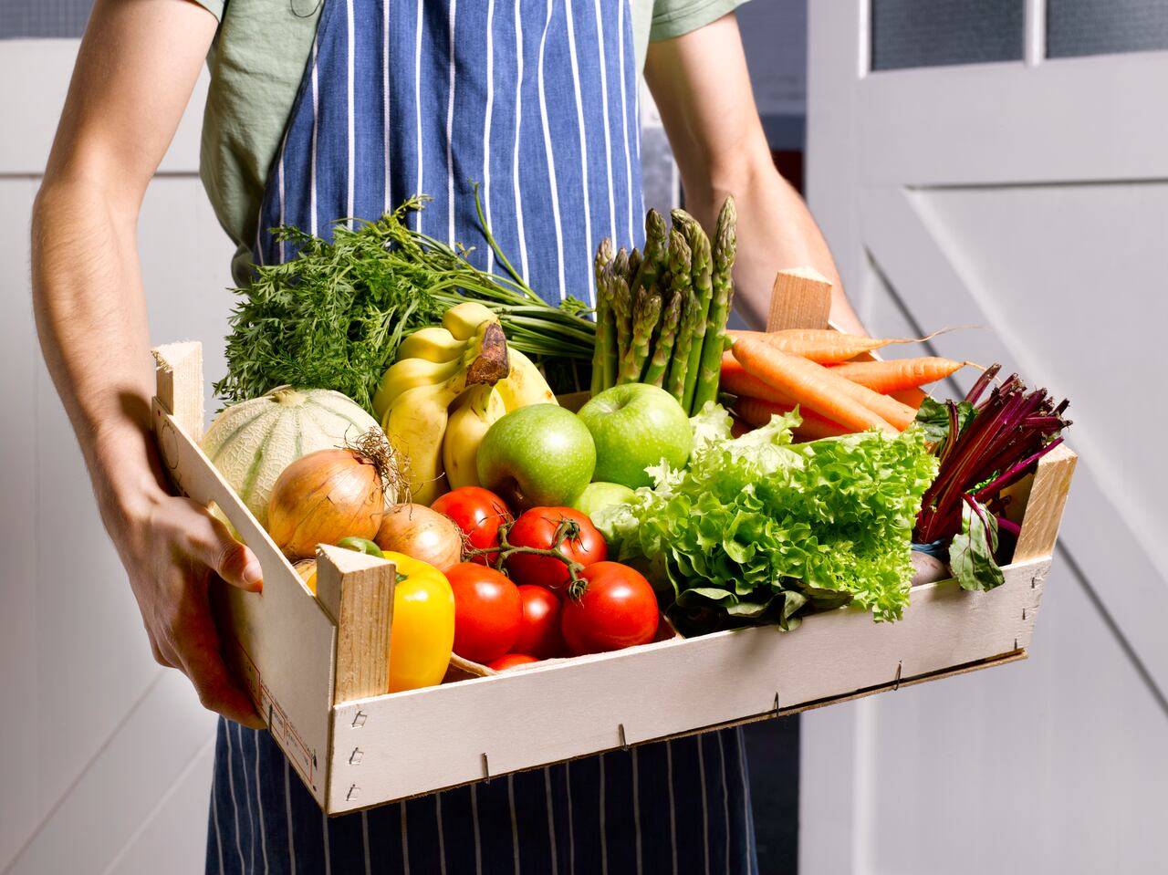 Hombre entregando caja de frutas y verduras
