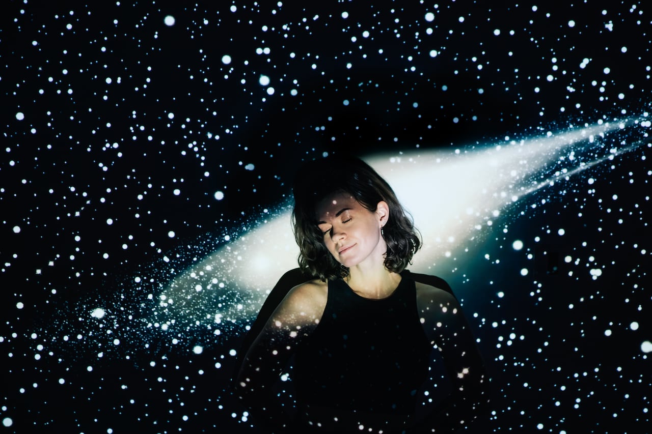 Image projection of space on a young beautiful woman with short curly hair.