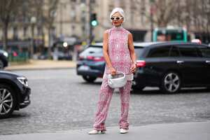 PARIS, FRANCE - JANUARY 23: Grece Ghanem wears white sunglasses, silver earrings from Chanel, a silver and pink embroidered rhinestones pattern turtleneck / sleeveless long t-shirt, matching silver and pink embroidered rhinestones pattern wide legs pants, a silver Serpenti watch from Bulgari, a gold Juste Un Clou ring from Cartier, a silver Messika ring, a silver shiny leather braided Jodie handbag from Bottega Veneta, white matte leather pointed / block heels ankle boots , outside Georges Hobeika, during Paris Fashion Week - Haute Couture Spring Summer, on January 23, 2023 in Paris, France. (Photo by Edward Berthelot/Getty Images)