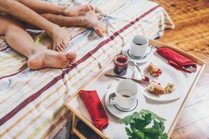 Anonymous image of heterosexual couple making love after some breakfast in bed