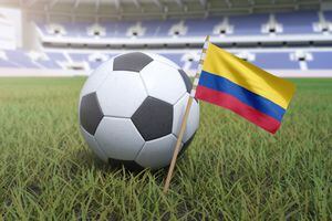 Bandera colombiana en el campo del estadio con fútbol soccer